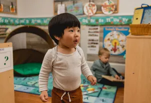A curious toddler in a Little Sprouts classroom
