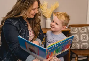 A teacher and student reading I Am a Rainbow by Dolly Parton 