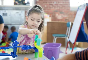 Preschooler playing with plastic building pieces 