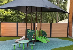 Age-appropriate, nature-inspired outdoor playground at Little Sprouts in Marlborough, MA, featuring shaded play equipment designed for safe, active learning