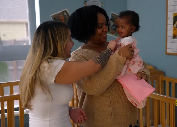 Teachers holding a baby in the infant classroom