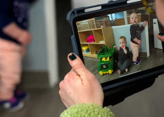 Little Sprouts educator providing child updates to parents using photos 