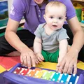 Teacher and baby using a colorful musical instrument 