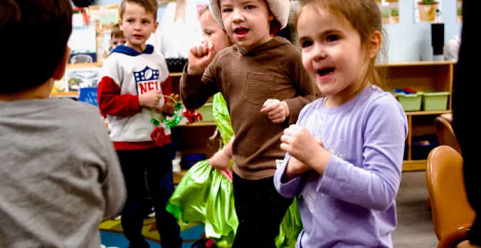 Little Sprouts toddlers smiling and dancing in the classroom